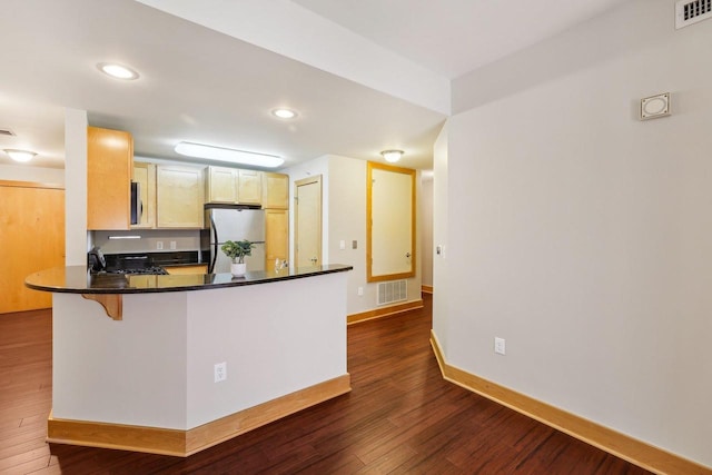 333 W Mifflin St Unit 8100, Madison, WI 53703 - kitchen featuring appliances with stainless steel finishes, dark wood finished floors, baseboards, a peninsula, and dark countertops