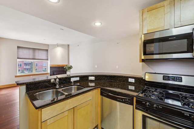 333 W Mifflin St Unit 8100, Madison, WI 53703 - kitchen with stainless steel appliances, a sink, light brown cabinets, dark stone counters, and wood finished floors