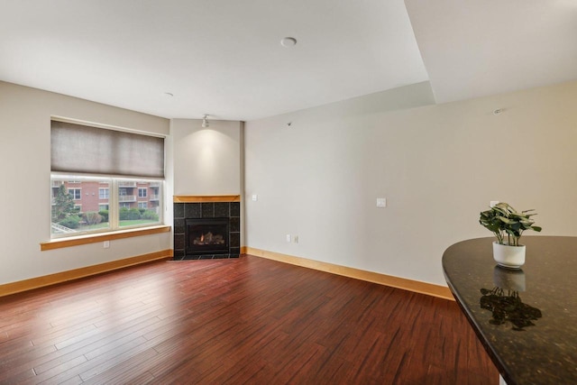 333 W Mifflin St Unit 8100, Madison, WI 53703 - unfurnished living room featuring dark wood-style floors, baseboards, and a tile fireplace