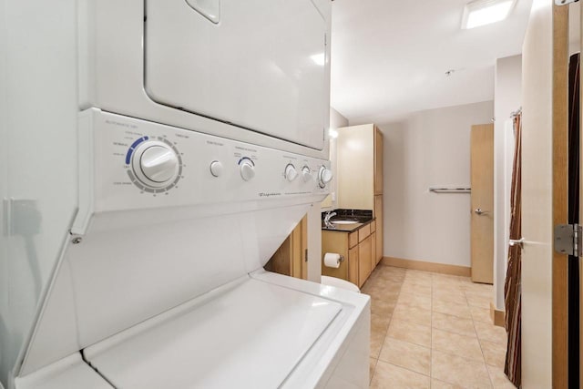333 W Mifflin St Unit 8100, Madison, WI 53703 - laundry area featuring stacked washer and clothes dryer, baseboards, and light tile patterned floors