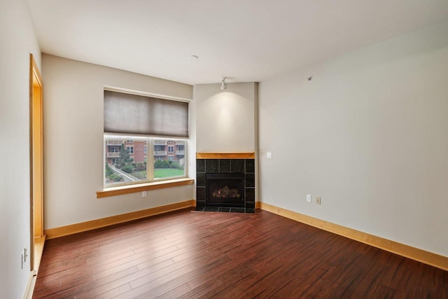 333 W Mifflin St Unit 8100, Madison, WI 53703 - unfurnished living room with wood finished floors, a tiled fireplace, and baseboards