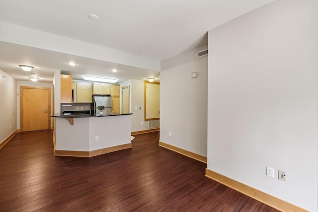 333 W Mifflin St Unit 8100, Madison, WI 53703 - kitchen featuring freestanding refrigerator, baseboards, dark wood-type flooring, dark countertops, and a peninsula