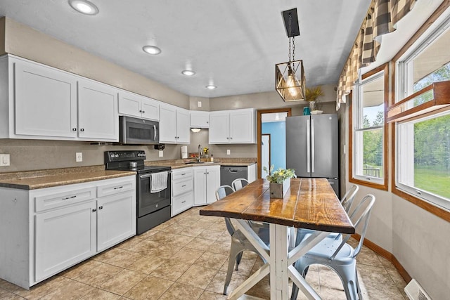 W4593 Old 352 Rd, Stephenson, MI 49887 - kitchen with stainless steel appliances, a sink, white cabinets, pendant lighting, and baseboards