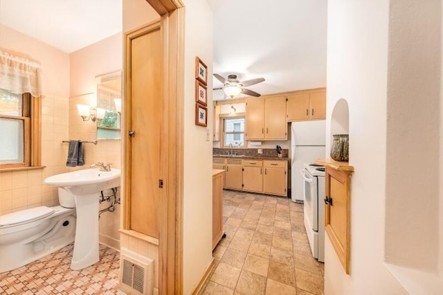 2114 S 81st St, West Allis, WI 53219 - kitchen featuring white appliances, a sink, ceiling fan, and light tile patterned floors