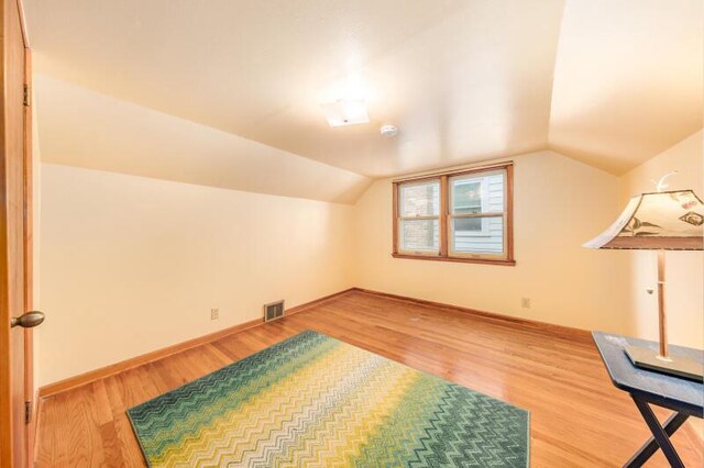 2114 S 81st St, West Allis, WI 53219 - bonus room with light wood finished floors, vaulted ceiling, and baseboards