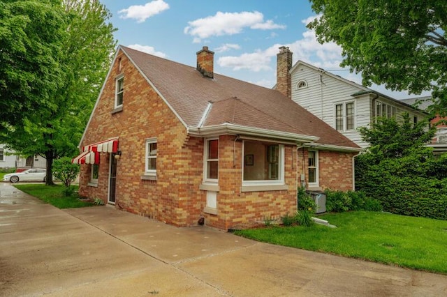 2114 S 81st St, West Allis, WI 53219 - view of side of property with brick siding, a lawn, a chimney, and roof with shingles
