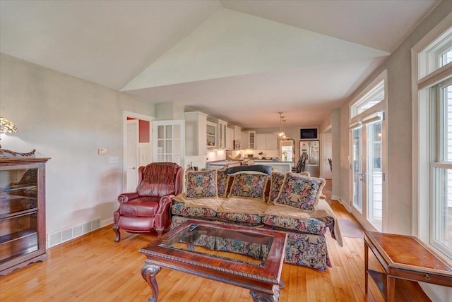 963 W Highland St, Whitewater, WI 53190 - living area featuring light wood finished floors, vaulted ceiling, and baseboards