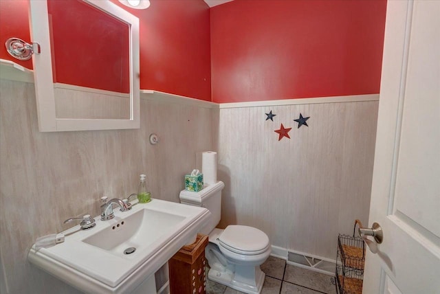 963 W Highland St, Whitewater, WI 53190 - half bathroom featuring toilet, a wainscoted wall, tile patterned flooring, and a sink