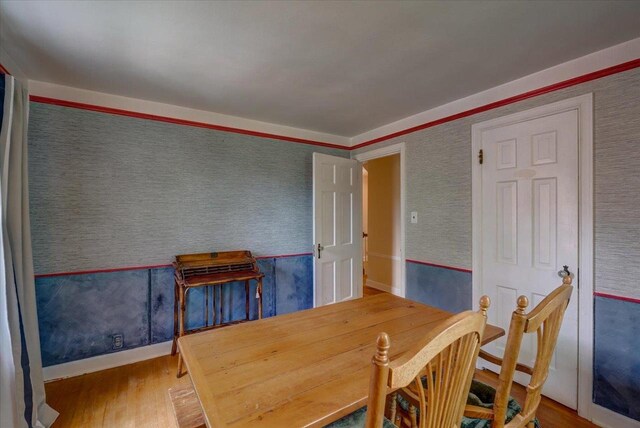 963 W Highland St, Whitewater, WI 53190 - dining area featuring wood finished floors, wallpapered walls, and baseboards