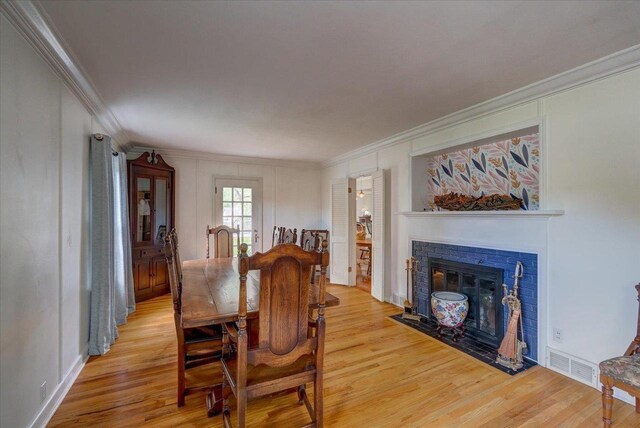 963 W Highland St, Whitewater, WI 53190 - dining room with light wood finished floors, crown molding, and a fireplace with flush hearth