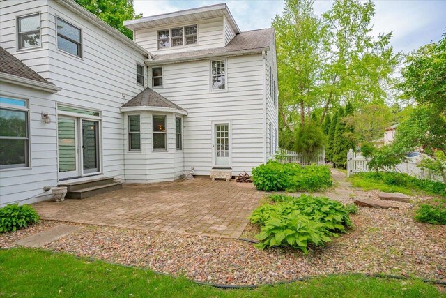 963 W Highland St, Whitewater, WI 53190 - back of property featuring entry steps, a patio area, and roof with shingles