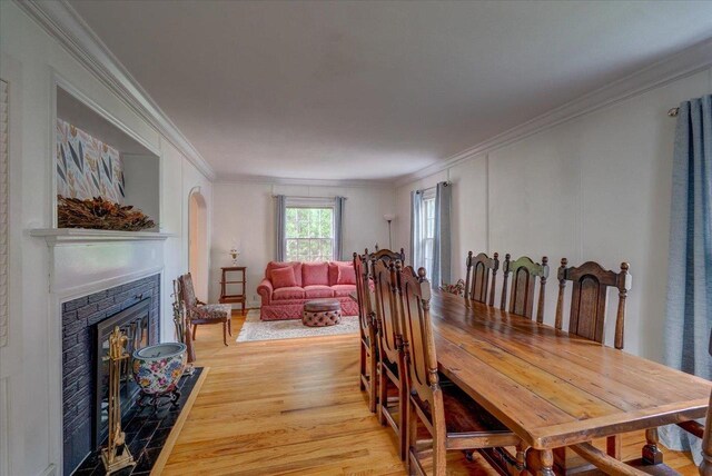 963 W Highland St, Whitewater, WI 53190 - dining space with light wood finished floors, ornamental molding, and a fireplace with flush hearth