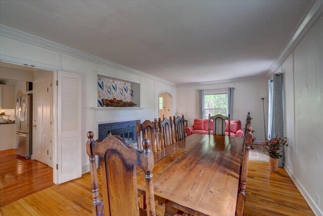 963 W Highland St, Whitewater, WI 53190 - dining space with light wood-style floors, crown molding, and a fireplace