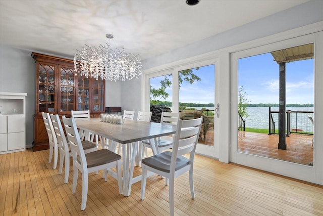 N60W39640 Mary Ln, Oconomowoc, WI 53066 - dining area featuring plenty of natural light, light wood-style floors, a chandelier, and a water view