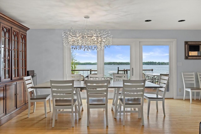 N60W39640 Mary Ln, Oconomowoc, WI 53066 - dining room featuring light wood finished floors, a chandelier, and a water view