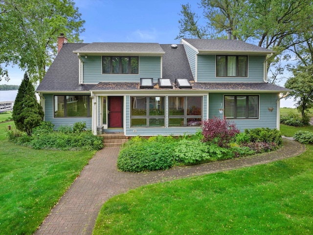 N60W39640 Mary Ln, Oconomowoc, WI 53066 - view of front of property featuring a chimney, a front lawn, and a shingled roof