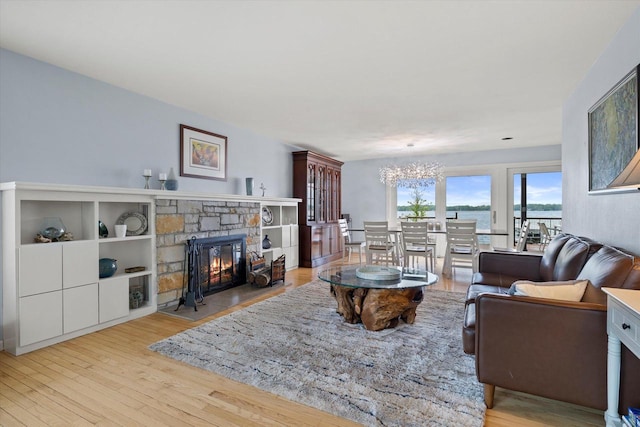 N60W39640 Mary Ln, Oconomowoc, WI 53066 - living area with a chandelier, wood finished floors, and a stone fireplace