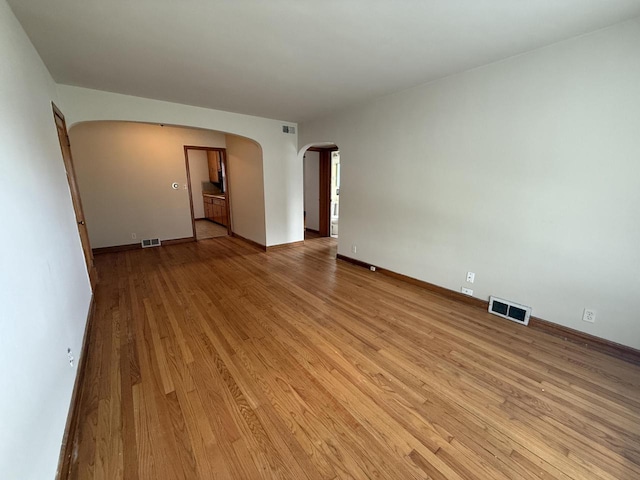2740 N 61st St, Milwaukee, WI 53210 - empty room with arched walkways, light wood-style floors, and baseboards
