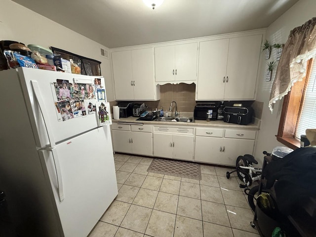 2740 N 61st St, Milwaukee, WI 53210 - kitchen featuring freestanding refrigerator, a sink, light countertops, light tile patterned floors, and backsplash