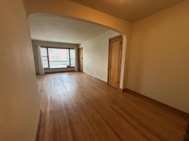 2740 N 61st St, Milwaukee, WI 53210 - unfurnished room with arched walkways, wood finished floors, and baseboards