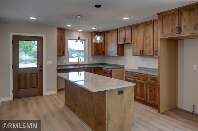 622 Pondhurst Dr, Amery, WI 54001 - kitchen with light wood-style flooring, brown cabinetry, a kitchen island, recessed lighting, and decorative light fixtures