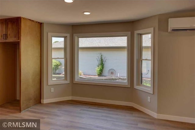 622 Pondhurst Dr, Amery, WI 54001 - unfurnished dining area with a wall unit AC, light wood-style flooring, and recessed lighting