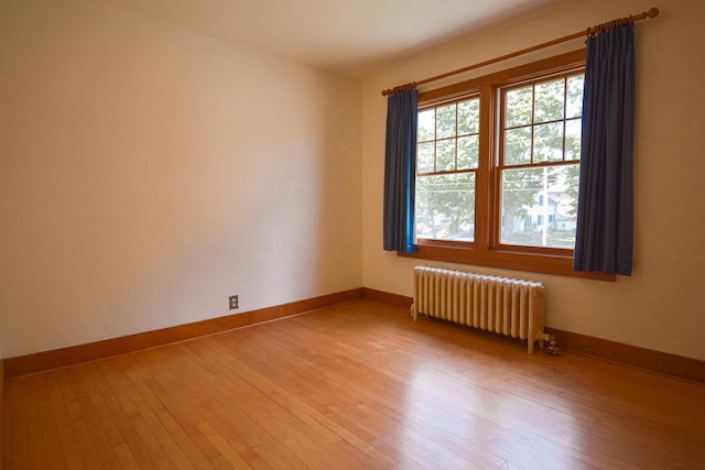 1139 W Highland St, Whitewater, WI 53190 - empty room featuring radiator, light wood-style flooring, and baseboards