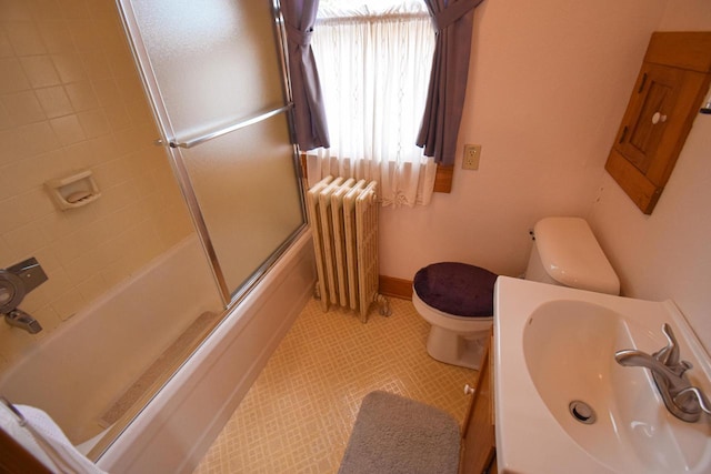1139 W Highland St, Whitewater, WI 53190 - full bathroom featuring radiator, toilet, shower / bath combination with glass door, and vanity