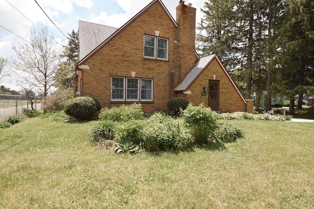 1139 W Highland St, Whitewater, WI 53190 - english style home featuring a chimney, brick siding, and a shingled roof