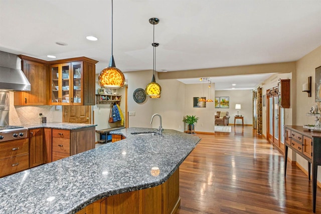 1136 W Ridge Rd, Marshfield, WI 54449 - kitchen featuring a sink, brown cabinetry, wall chimney exhaust hood, stainless steel gas cooktop, and dark wood-style flooring
