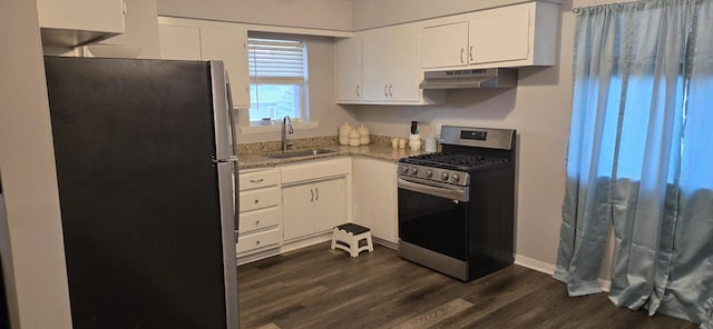 2112 Virginia St, Racine, WI 53405 - kitchen featuring appliances with stainless steel finishes, under cabinet range hood, a sink, white cabinets, and dark wood finished floors