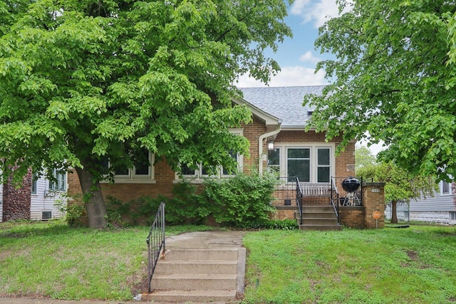 1608 S 60th St, West Allis, WI 53214 - view of front of house with a front lawn, brick siding, and a shingled roof