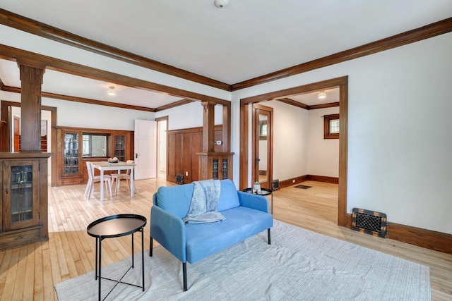 1551 N 50th St, Milwaukee, WI 53208 - living area featuring ornate columns, light wood finished floors, baseboards, crown molding, and plenty of natural light