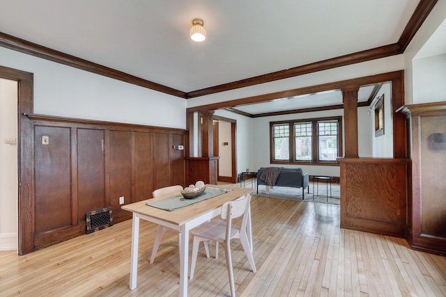 1551 N 50th St, Milwaukee, WI 53208 - dining space with light wood finished floors, ornate columns, ornamental molding, and a wainscoted wall