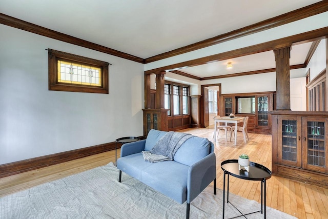 1551 N 50th St, Milwaukee, WI 53208 - living room with decorative columns, light wood-style flooring, crown molding, and baseboards