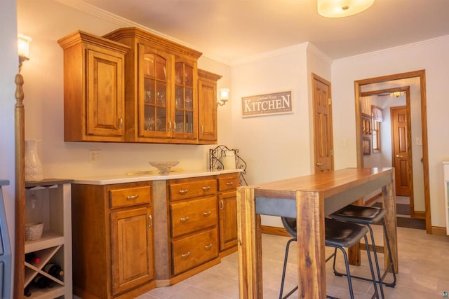 23920 US Highway 2, Ashland, WI 54806 - kitchen featuring brown cabinetry, ornamental molding, glass insert cabinets, light countertops, and light tile patterned flooring