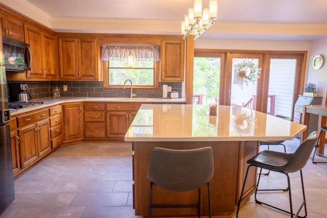 23920 US Highway 2, Ashland, WI 54806 - kitchen with a sink, a kitchen island, light countertops, brown cabinets, and black microwave