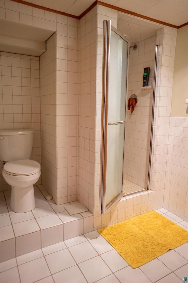 23920 US Highway 2, Ashland, WI 54806 - bathroom featuring tile walls, toilet, a shower stall, ornamental molding, and tile patterned floors