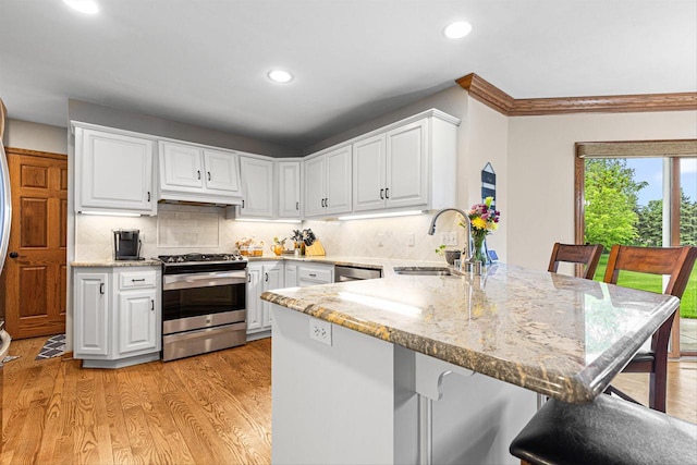 8806 W Daventry Rd, Mequon, WI 53097 - kitchen with appliances with stainless steel finishes, a sink, a peninsula, recessed lighting, and white cabinetry