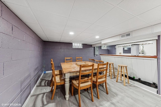 2300 W Lawn Ave, Racine, WI 53405 - dining area featuring light wood finished floors, concrete block wall, and a paneled ceiling