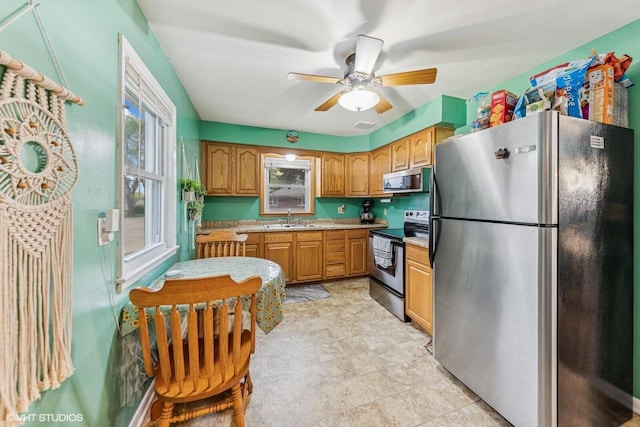 2300 W Lawn Ave, Racine, WI 53405 - kitchen with stainless steel appliances, a sink, light countertops, and ceiling fan