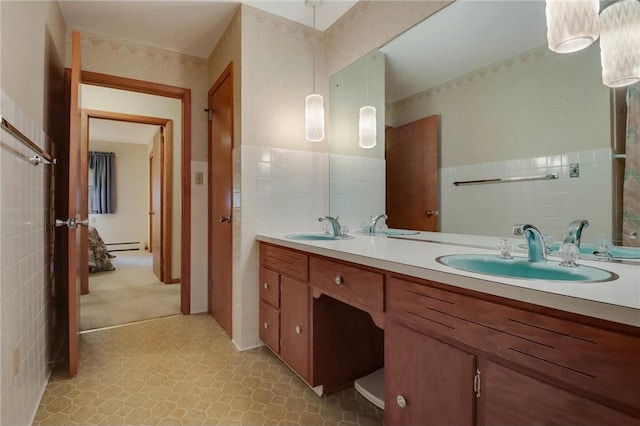 407 S Scott St, Elmwood, WI 54740 - full bathroom featuring tile walls, double vanity, a baseboard radiator, tile patterned floors, and a wainscoted wall
