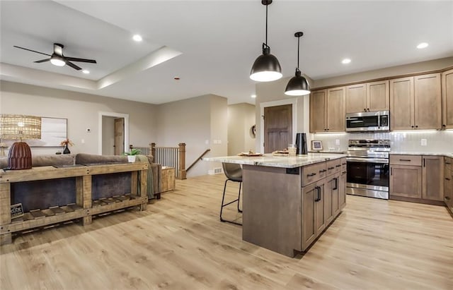 4098 141st St, Chippewa Falls, WI 54729 - kitchen featuring stainless steel appliances, open floor plan, light wood finished floors, a kitchen breakfast bar, and recessed lighting