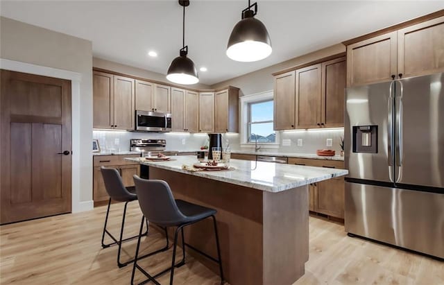 4098 141st St, Chippewa Falls, WI 54729 - kitchen featuring stainless steel appliances, a kitchen island, light wood-style flooring, light stone countertops, and recessed lighting