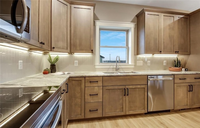 4098 141st St, Chippewa Falls, WI 54729 - kitchen featuring appliances with stainless steel finishes, a sink, light wood-style floors, and tasteful backsplash