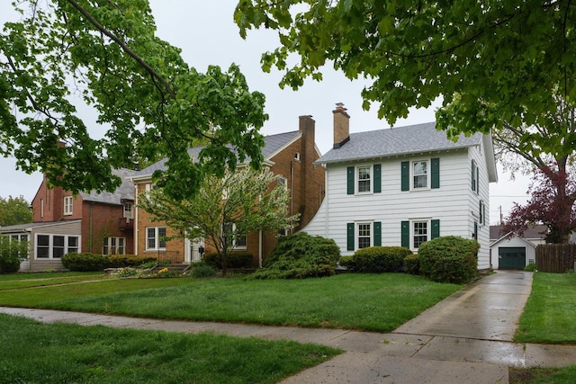 7312 5th Ave, Kenosha, WI 53143 - view of front of home featuring a front yard, driveway, a garage, and a chimney