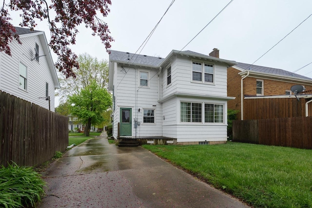 7312 5th Ave, Kenosha, WI 53143 - rear view of house with concrete driveway, a chimney, and entry steps