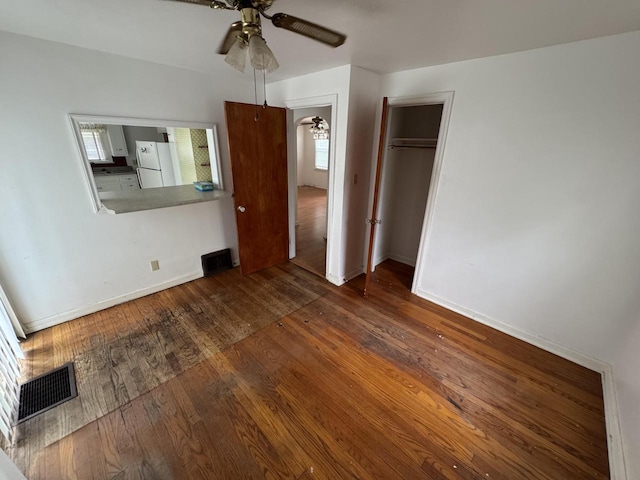 7715 18th Ave, Kenosha, WI 53143 - unfurnished bedroom featuring freestanding refrigerator, baseboards, wood finished floors, and a ceiling fan
