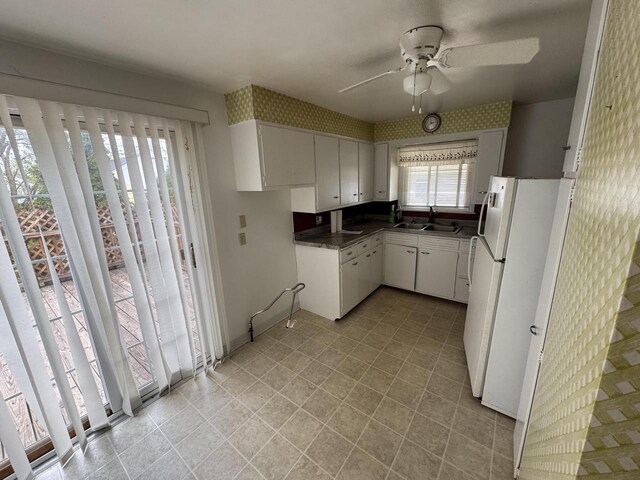 7715 18th Ave, Kenosha, WI 53143 - kitchen with a sink, ceiling fan, freestanding refrigerator, wallpapered walls, and dark countertops