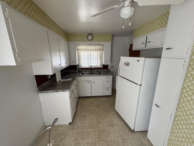 7715 18th Ave, Kenosha, WI 53143 - kitchen featuring freestanding refrigerator, a sink, a ceiling fan, light tile patterned floors, and white cabinetry